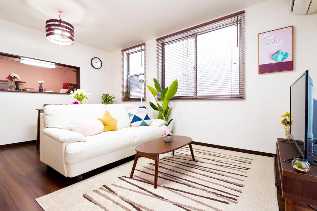 a living room with a white couch and a table at 新宿顶级奢华三层独栋别墅/车站5分钟/儿童房/8人 in Tokyo