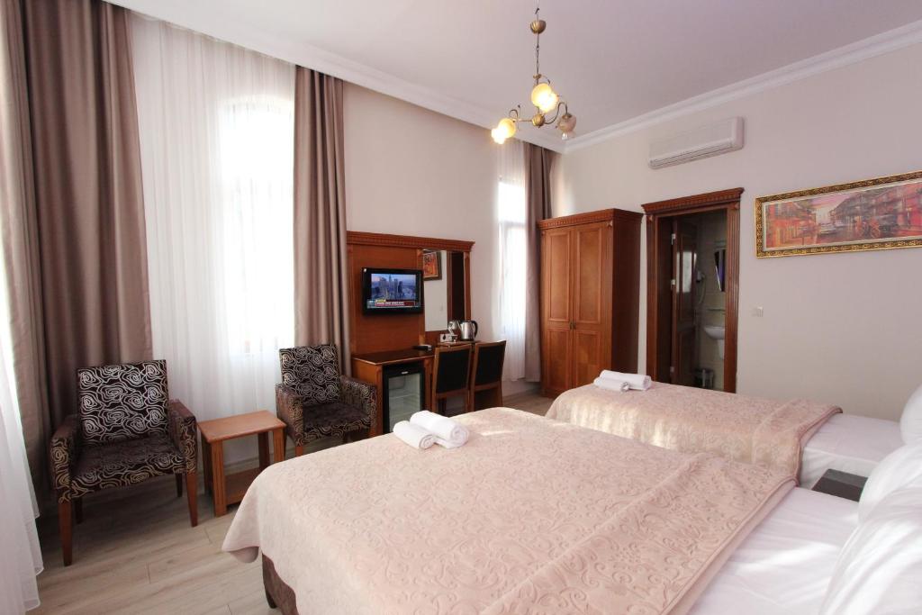 a hotel room with two beds and a desk at Hotel New House in Istanbul