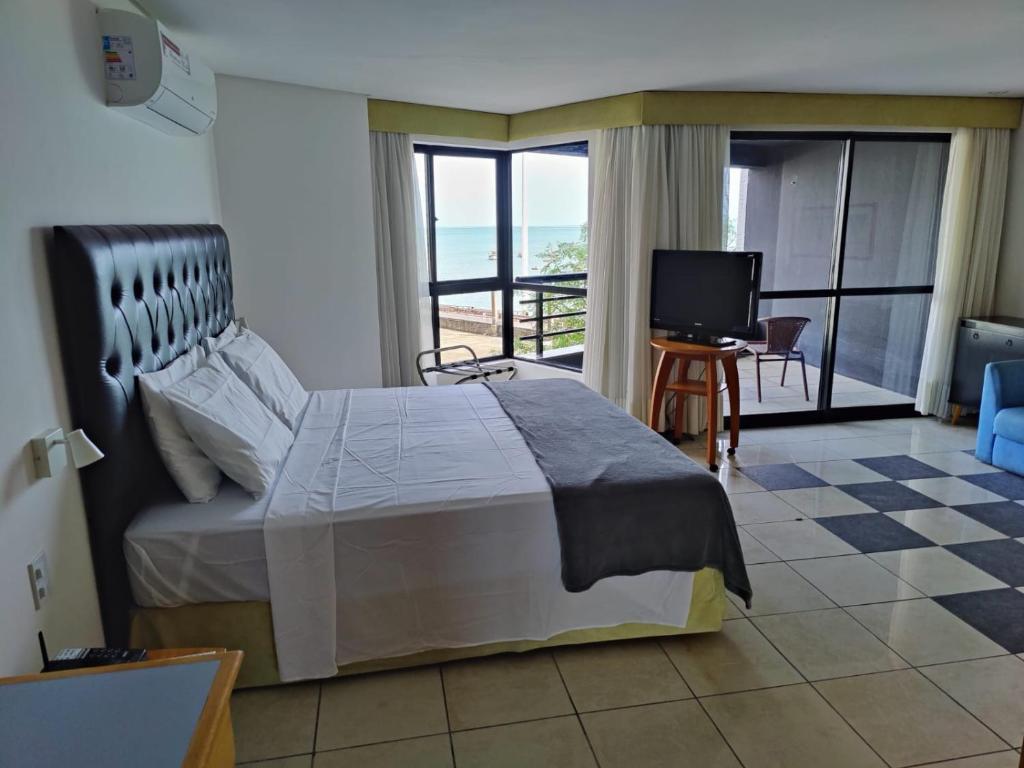 a bedroom with a bed and a view of the ocean at PRAIA DE MUCURIPE - FRENTE MAR - Ap205 in Fortaleza