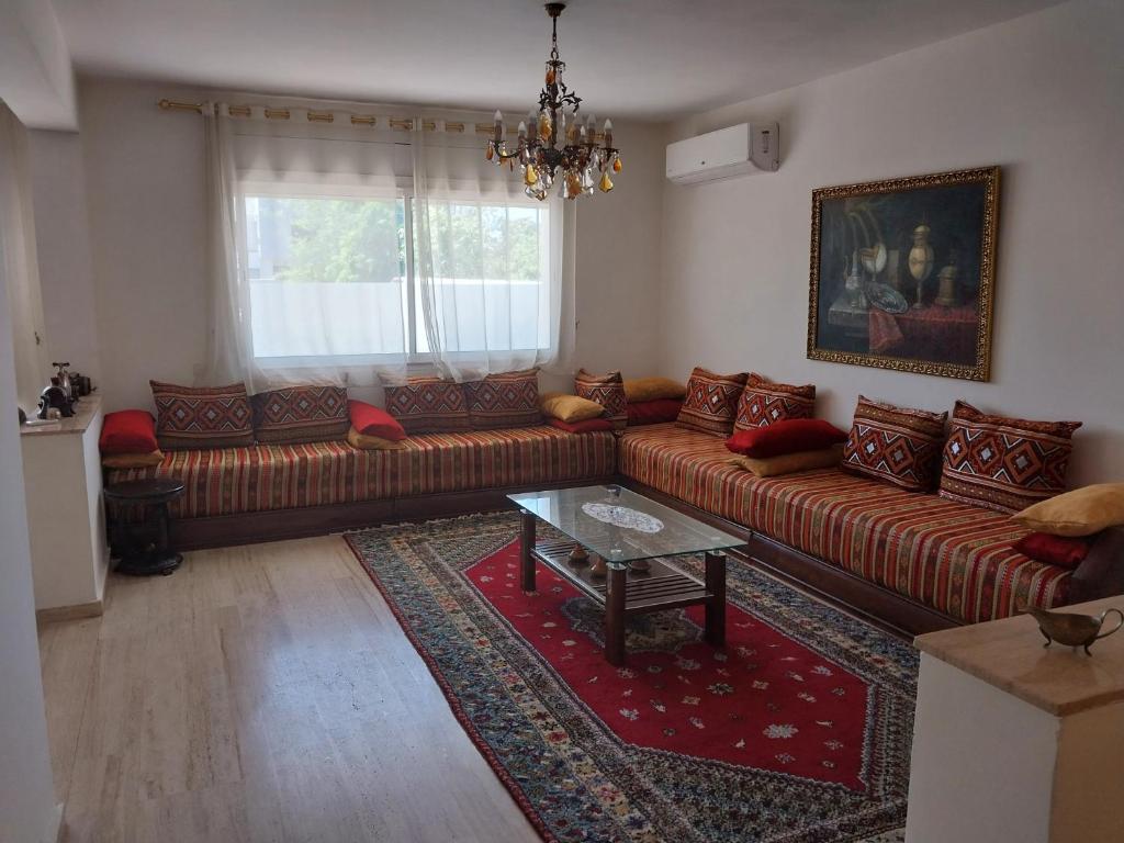 Appartement Hay Riad في الرباط: غرفة معيشة مع أريكة وطاولة