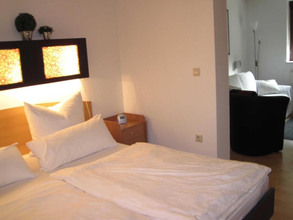 a bedroom with a bed with white sheets and pillows at Ferienwohnung Benz-Boch in Lahr