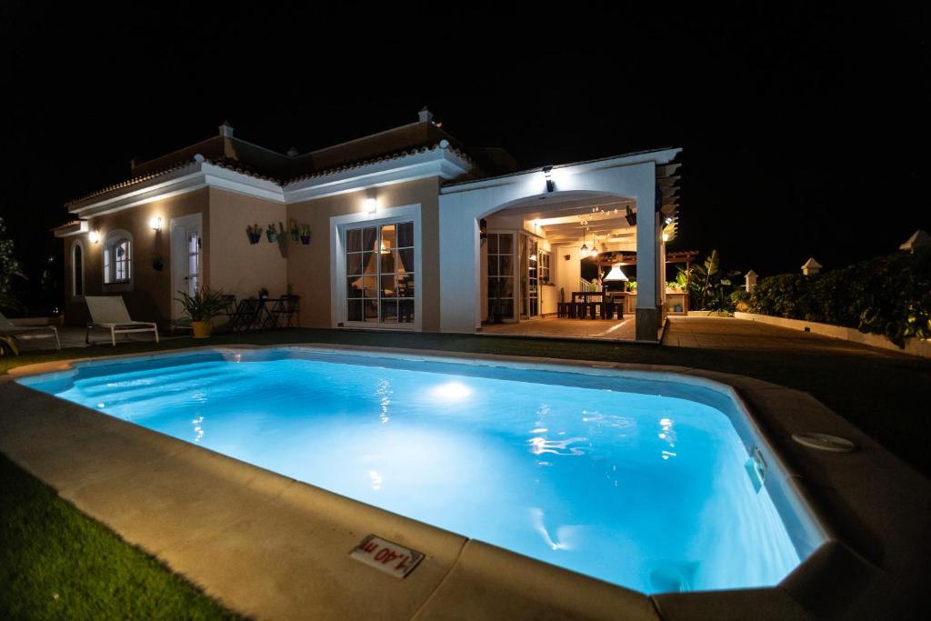 una piscina frente a una casa por la noche en El Olivar Beach Golf, en Caleta de Fuste