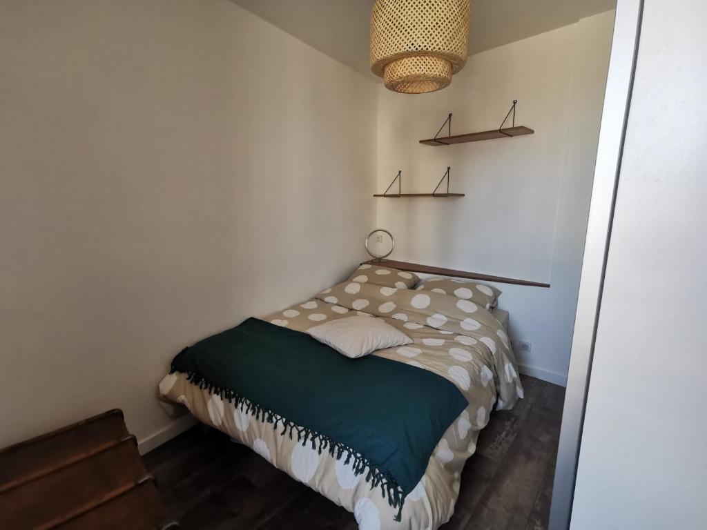 - une petite chambre avec un lit et une lampe dans l'établissement Les chants du crépuscule, à Granville