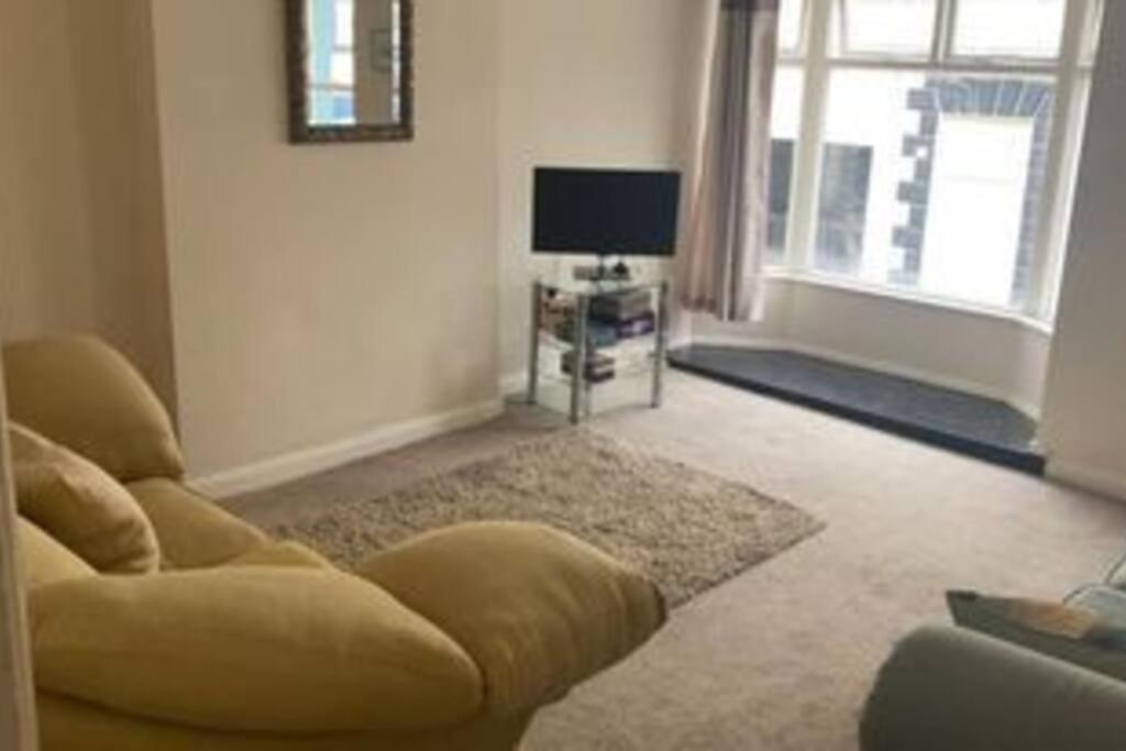 a living room with a couch and a television at Julia’s flat in Maryport