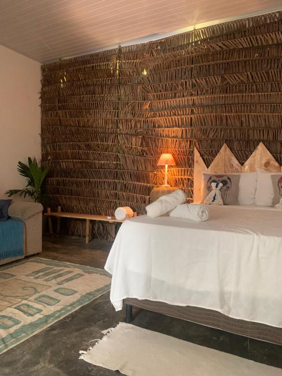 a bedroom with a white bed and a wooden wall at Jardim Azul in Pitimbu