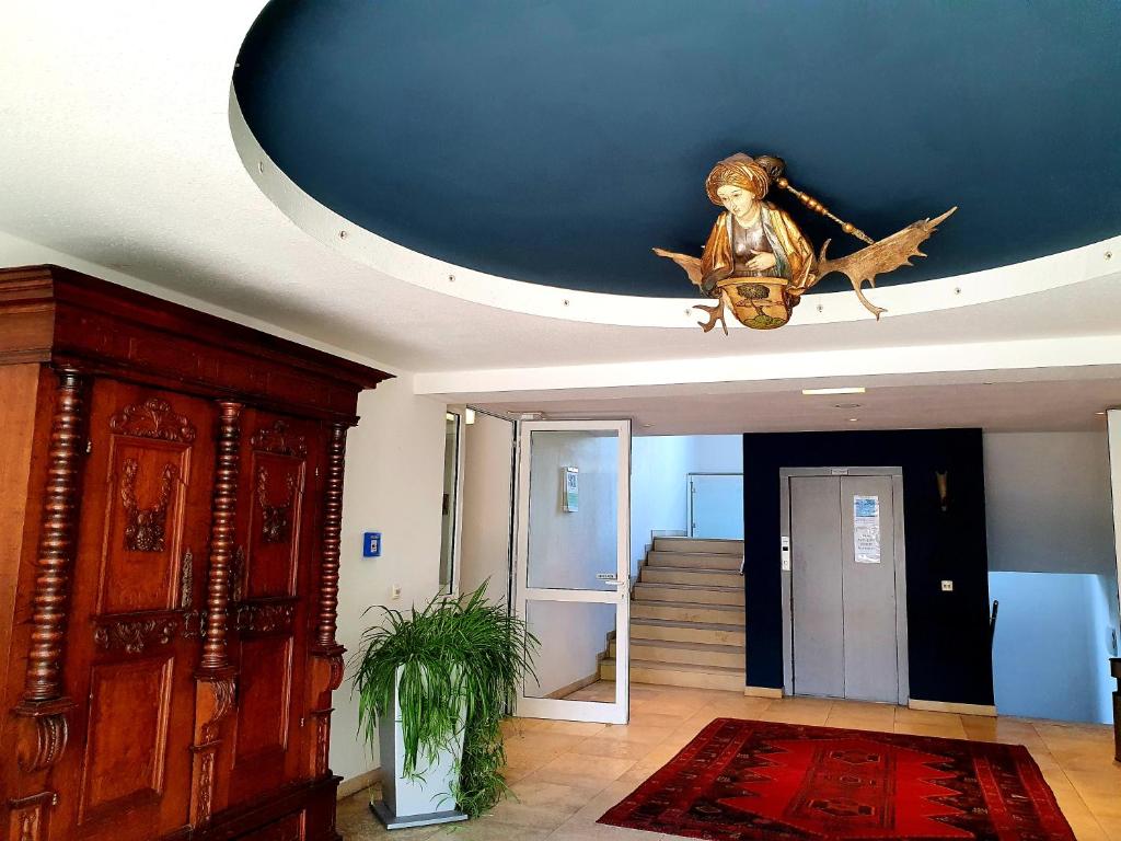 a living room with a ceiling with a statue of a bird at Romantik Hotel Gasthaus Rottner in Nuremberg