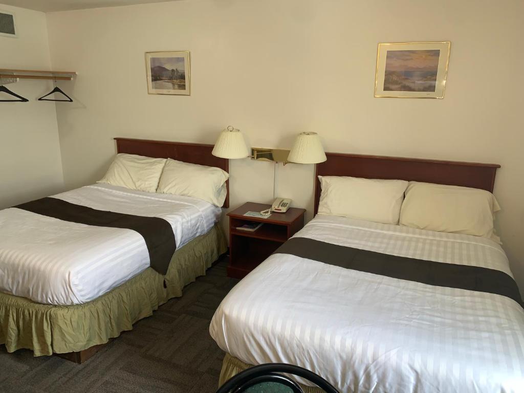 a hotel room with two beds and a telephone at Destination Family Hotel in Whitehorse