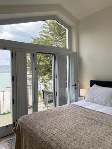 ein Schlafzimmer mit einem Bett und einem großen Fenster in der Unterkunft The Boathouse, at the lake in Magione