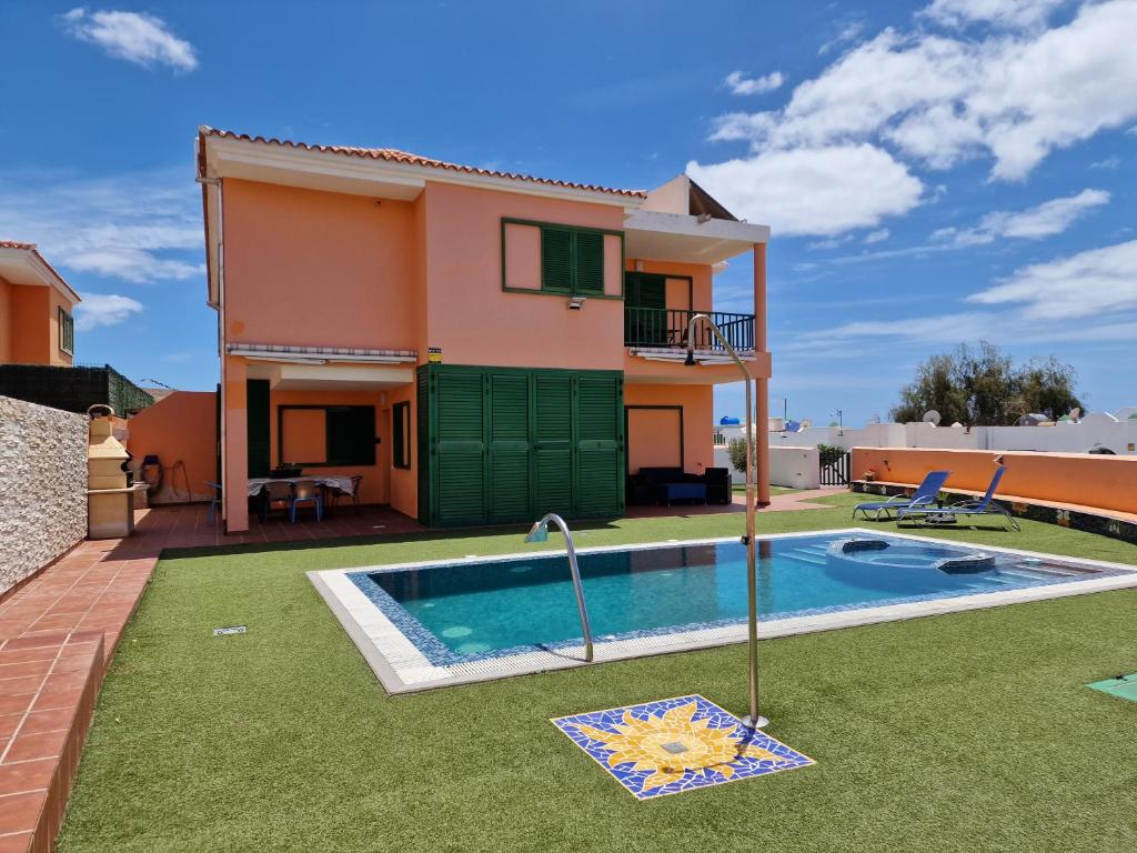a villa with a swimming pool and a house at TaraVilla in Tarajalejo