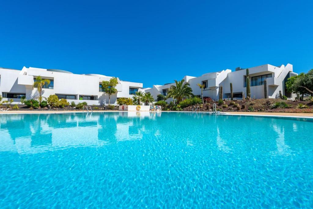 ein großer Pool vor einigen Häusern in der Unterkunft Casilla de Costa in Villaverde