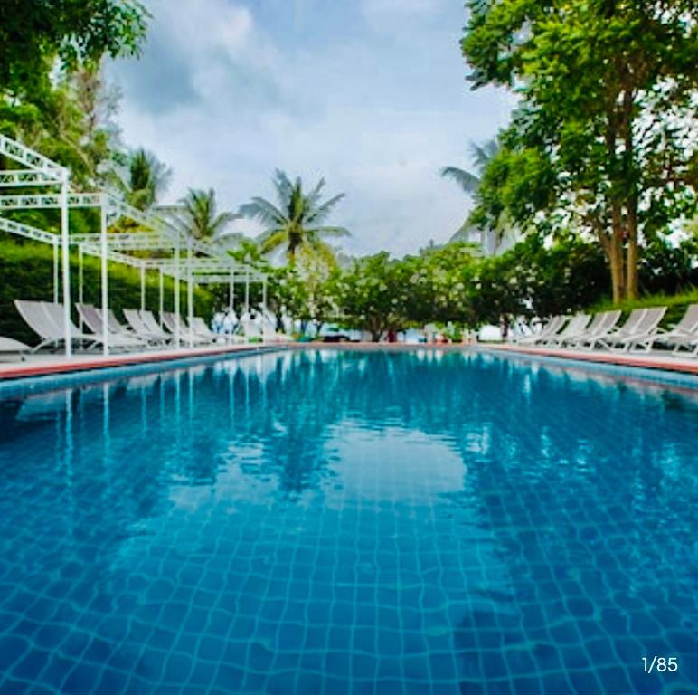 a large swimming pool with chairs and trees at Da Kanda Villa Beach Resort in Thong Sala