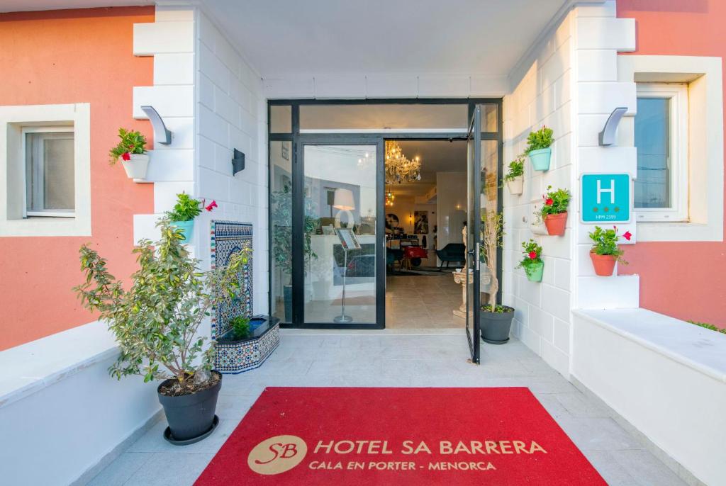 a hotel entrance with a red rug in front of it at Hotel Sa Barrera - Adults Only in Cala en Porter