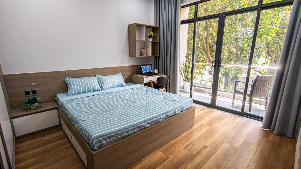 - une chambre avec un lit et une grande fenêtre dans l'établissement Marki Home, à Hô-Chi-Minh-Ville