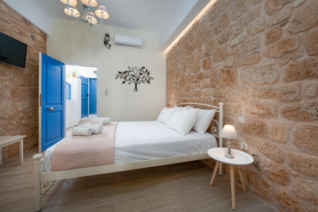 a bedroom with a bed and a brick wall at gdk house in the heart of Aegina in Aegina Town