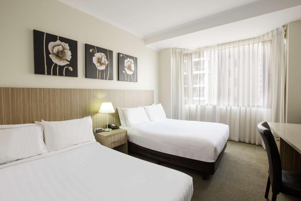 a hotel room with two beds and a window at Metro Hotel Marlow Sydney Central in Sydney