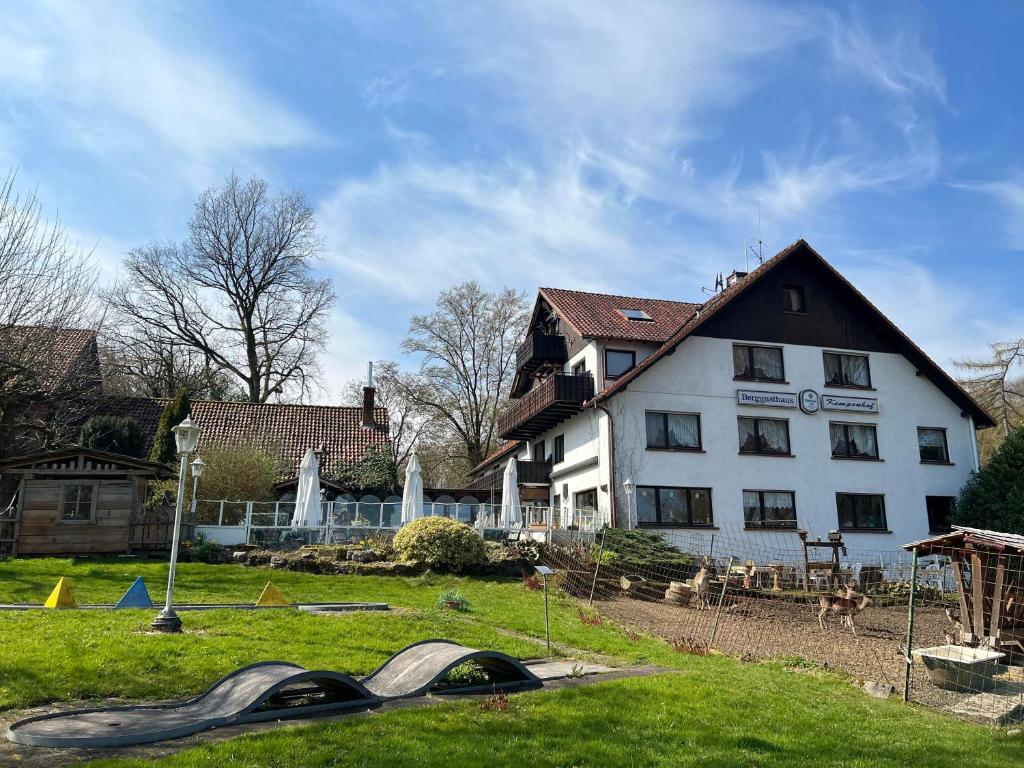 een groot wit huis in een tuin met een parachute bij Hotel Kempenhof in Lügde