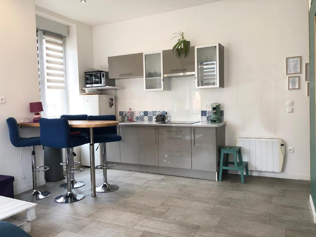 a kitchen with a table and some blue chairs at joli appart au centre de Lyon in Lyon