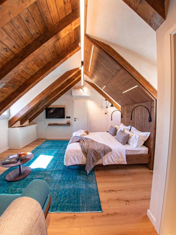 an attic bedroom with a large bed and a blue rug at Villa Porta Maestra in Hvar
