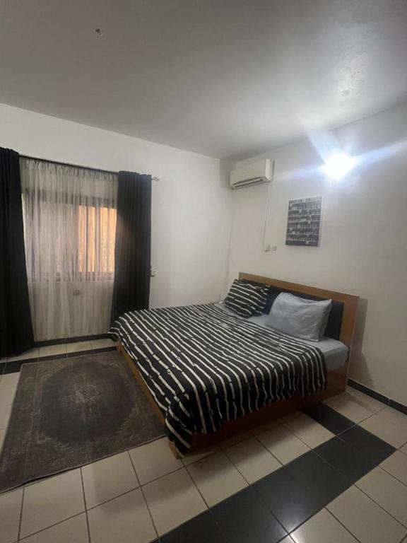 a bedroom with a bed and a window at Nova Room 1 - Private Room in a Condo in Abuja