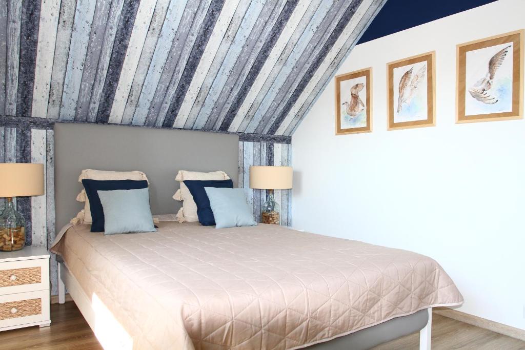 a bedroom with a large bed with blue pillows at Biały Domek in Stegna
