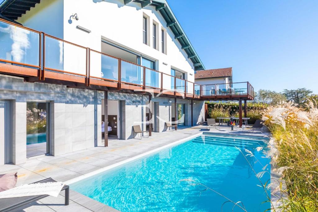 a house with a swimming pool and a balcony at Easy Clés - Villa Jacuzzi Pool AC in Saint-Jean-de-Luz
