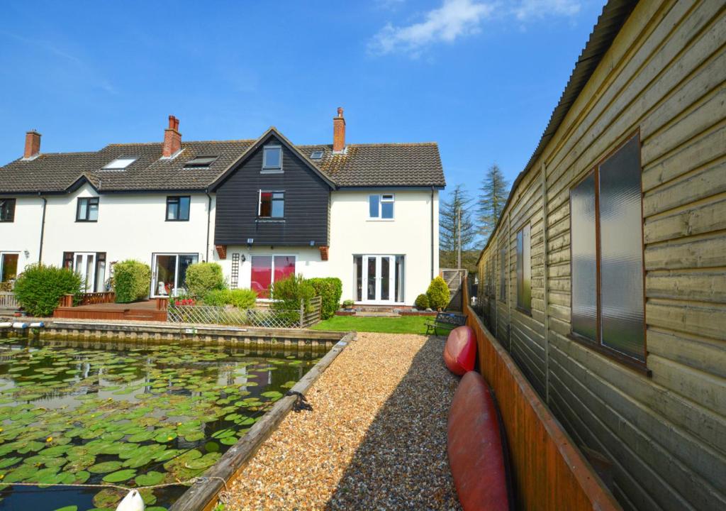 a house with a pond in front of a house at 20 Trail Quay Cottages in Hoveton