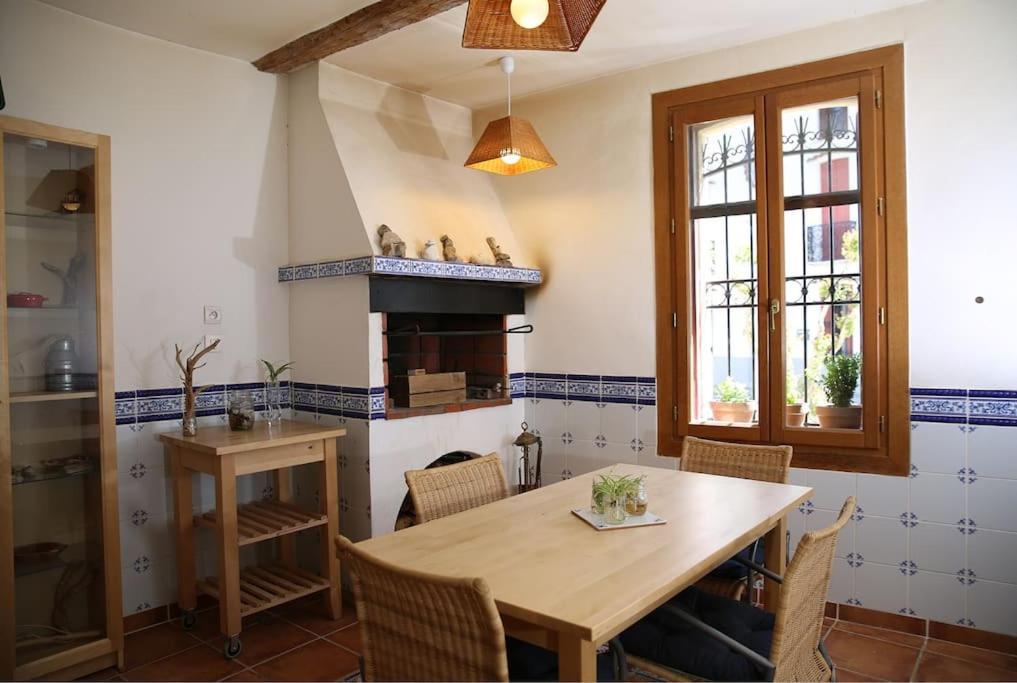 une cuisine avec une table en bois et une cheminée dans l'établissement Beautiful downtown house, à Argelès-sur-Mer