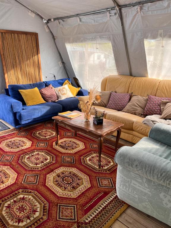 a living room with couches and a table in a tent at Aparra Surfcamp Hendaye in Hendaye