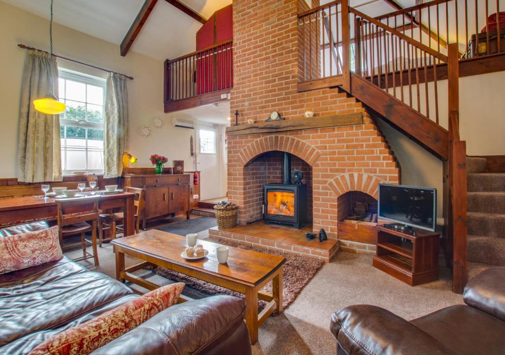 a living room with a large brick fireplace at The Old Chapel in Banningham