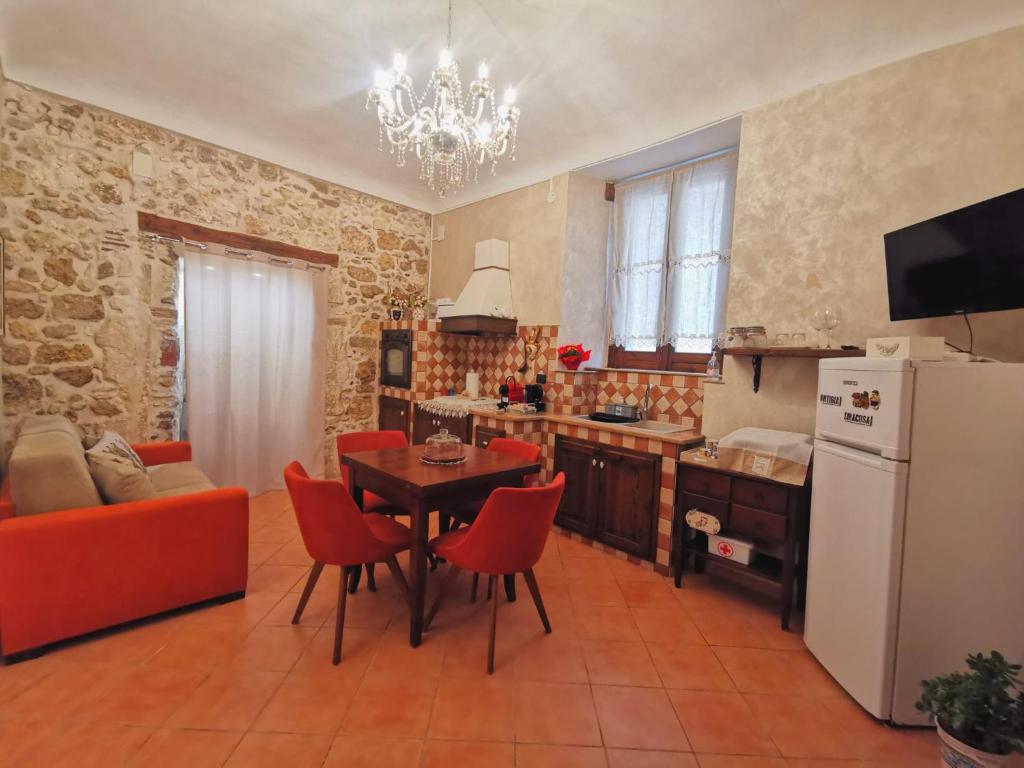 a kitchen with a table and red chairs in a room at Home Kitó Ortigia in Syracuse