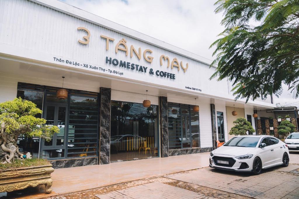 a white car parked in front of a building at 3 Tầng Mây (Homestay & Coffee) in Ấp Ða Lôc