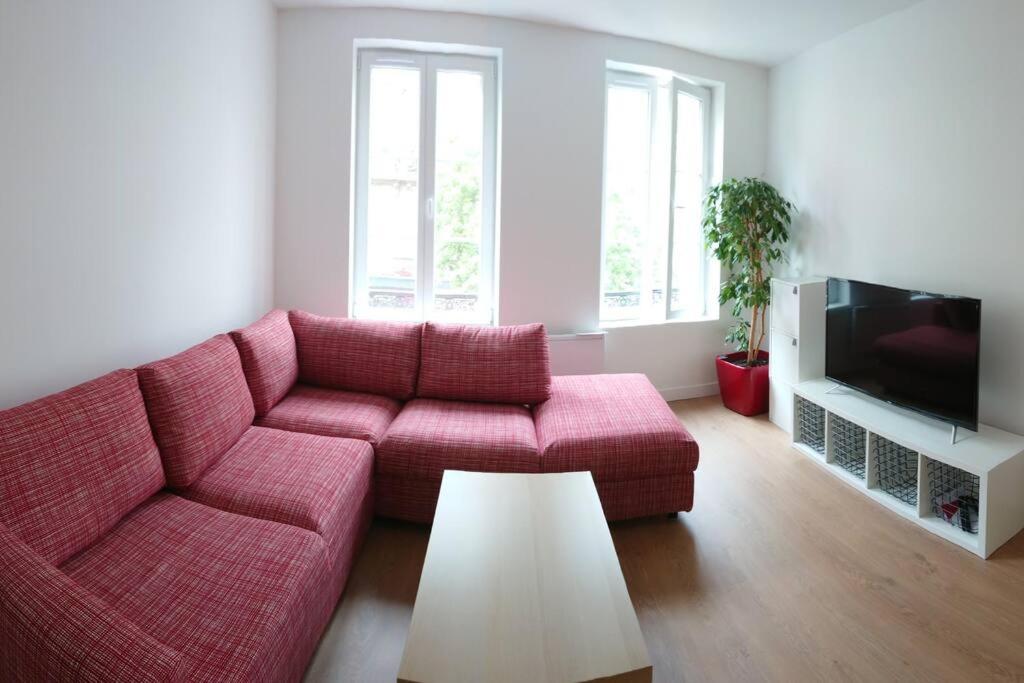 a living room with a red couch and a tv at Vivez en Duplex plein centre ville in Le Havre