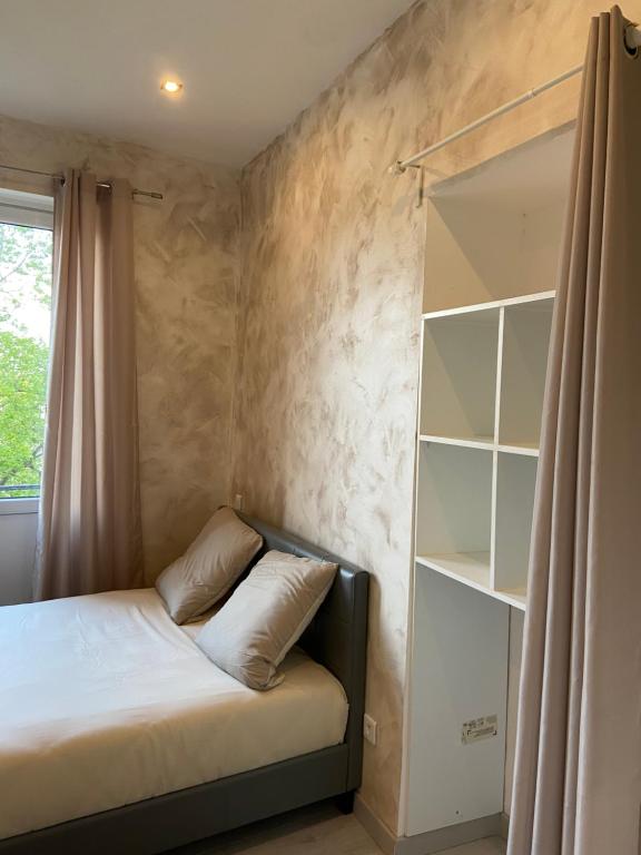 una piccola camera con letto e libreria di Appartement Belfort proche gare a Belfort