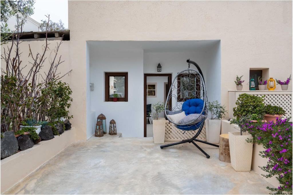 a room with a blue chair and some plants at Marilias Apartment in Kamari