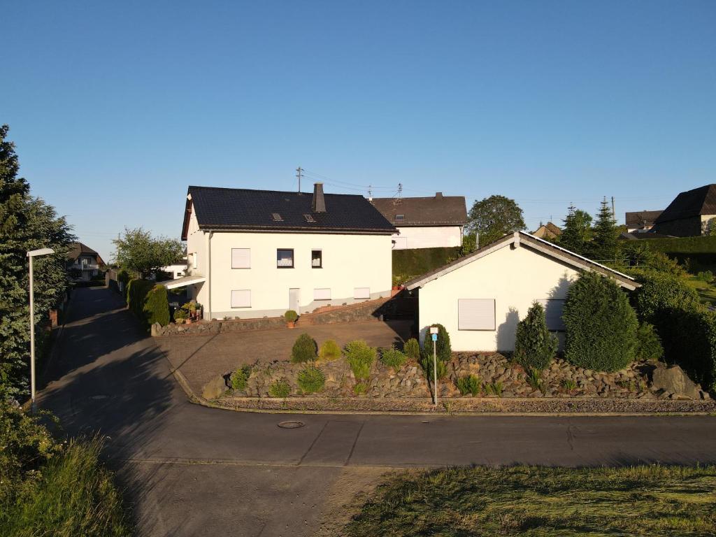 a white house and a street with a house at Ferienwohnung zum Nürburgring in Münk