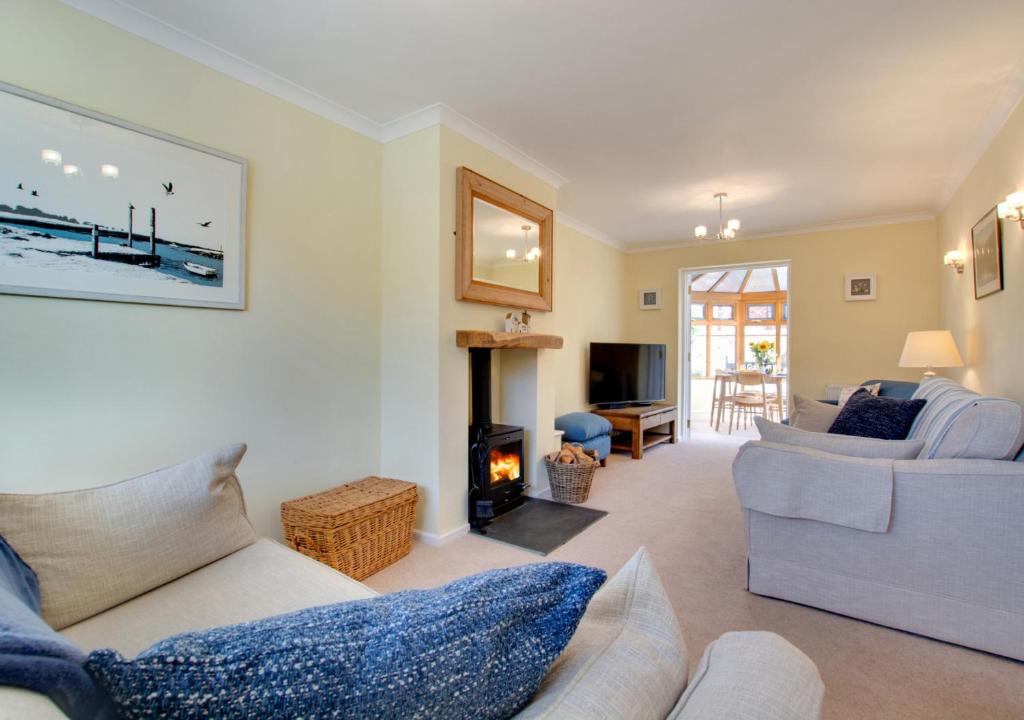 a living room with a couch and a fireplace at 1 Street Farm Cottages in Bodham