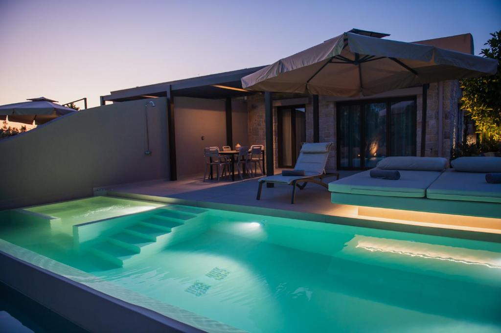 a swimming pool in front of a house at Nestor Luxury Villas with Private Pools in Romanós