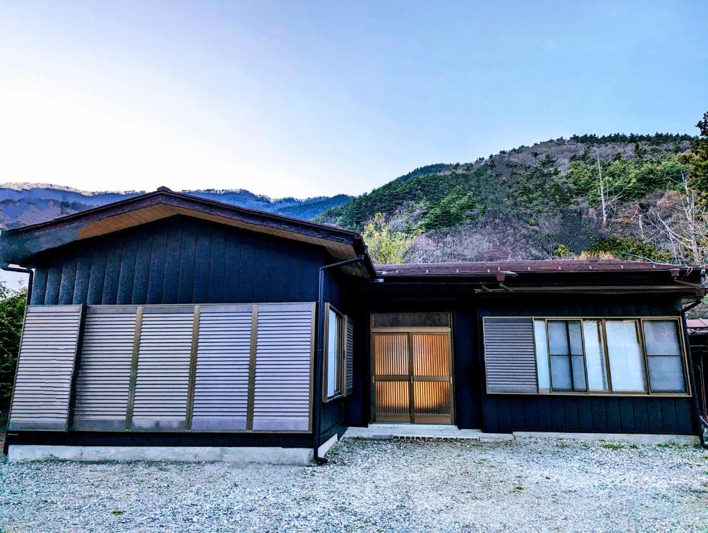 a blue house with a mountain in the background at Lake Kawaguchiko, Vacation House, 3LDK BBQ OK !! 竹之家-Takenoya- Perfect for famiry and group travel !! in Fujikawaguchiko
