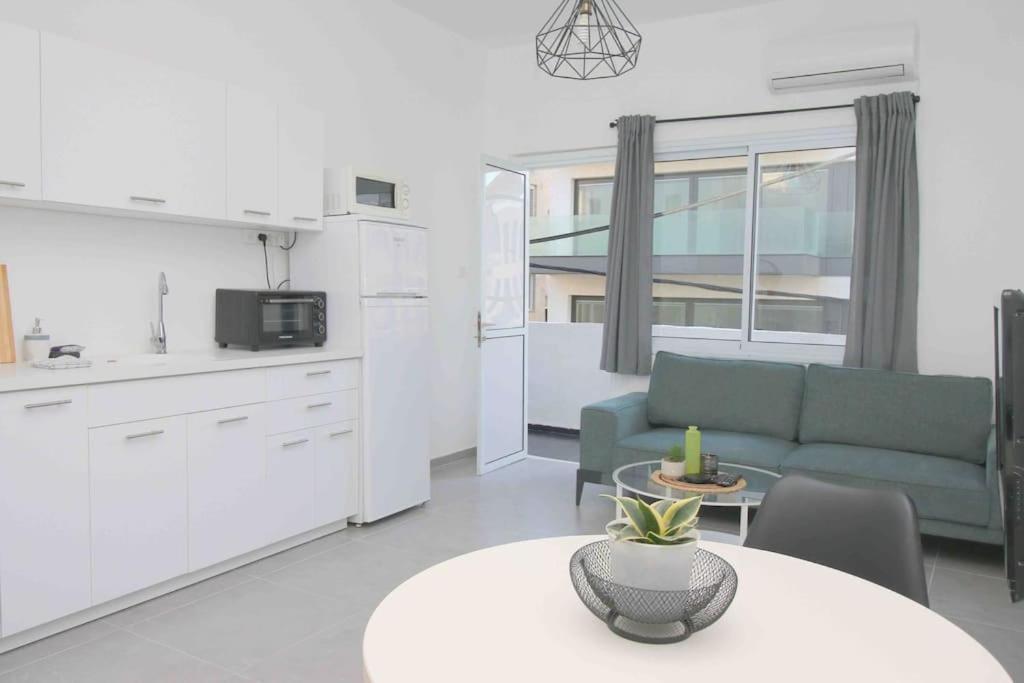 uma cozinha e uma sala de estar com um sofá e uma mesa em 4 Rooms steps from the beach em Tel Aviv