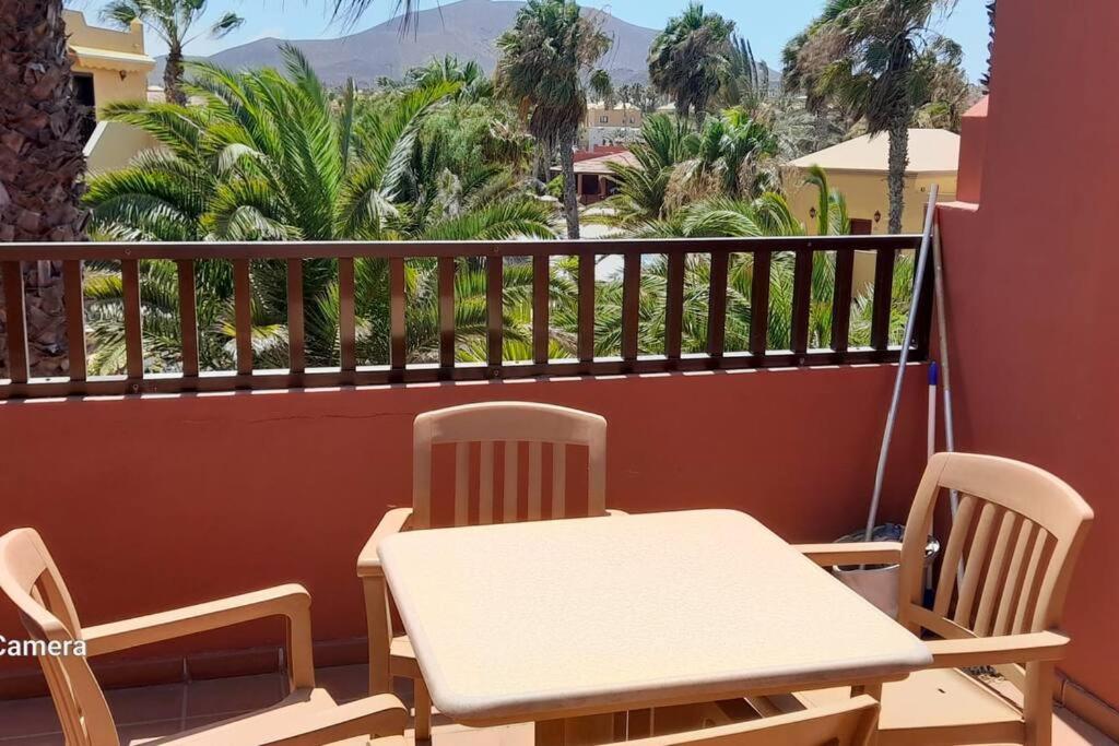 a table and chairs on a balcony with mountains in the background at Apartment Cumbre Vieja Fuerteventura in Corralejo