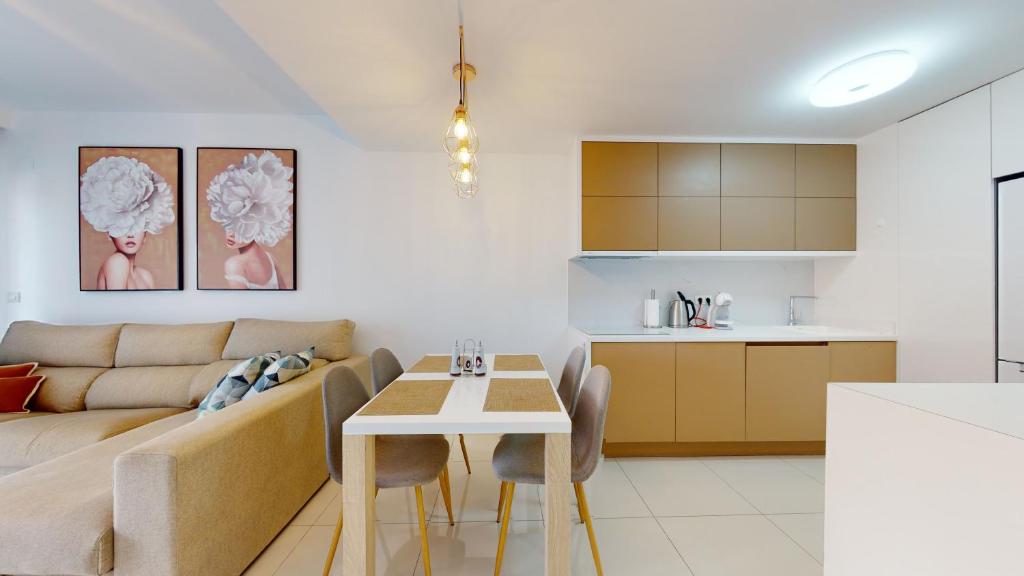 皮拉爾德拉奧拉達達的住宿－Apartamento Bianca Beach，客厅以及带沙发和桌子的厨房。