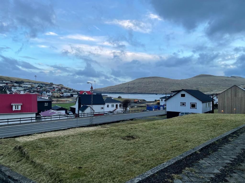 una pequeña ciudad con casas y un cuerpo de agua en GiljaHome, en Sandavágur