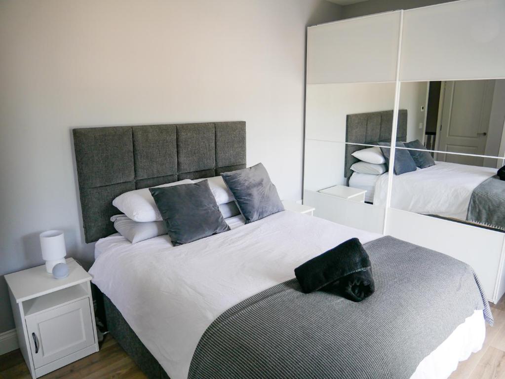 a bedroom with two beds and a large mirror at Entire Modern Home with seaview and parking in Wicklow