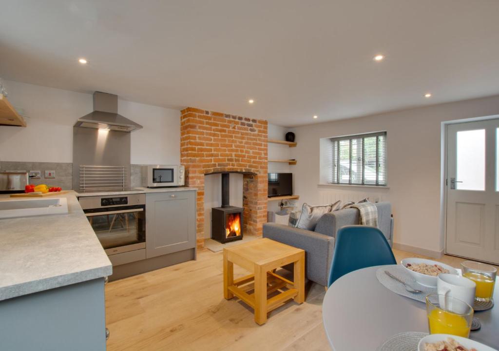a kitchen and living room with a table and a stove at 3 Port in Holt