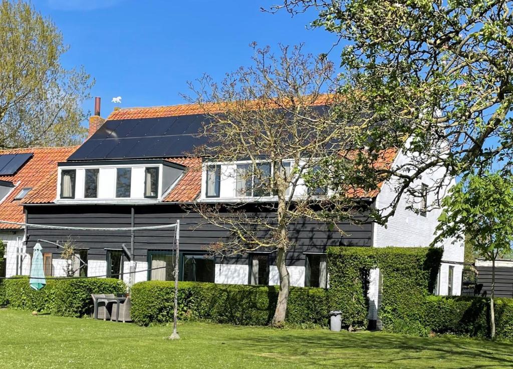 une maison avec un panneau solaire sur son toit dans l'établissement Vakantieoord "de Peppelhoeve", à Koudekerke