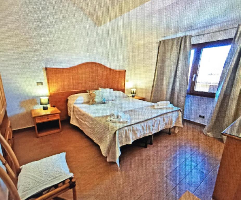 帕勞的住宿－LE CAMERE SUL PORTO，一间卧室设有一张大床和一个窗户。