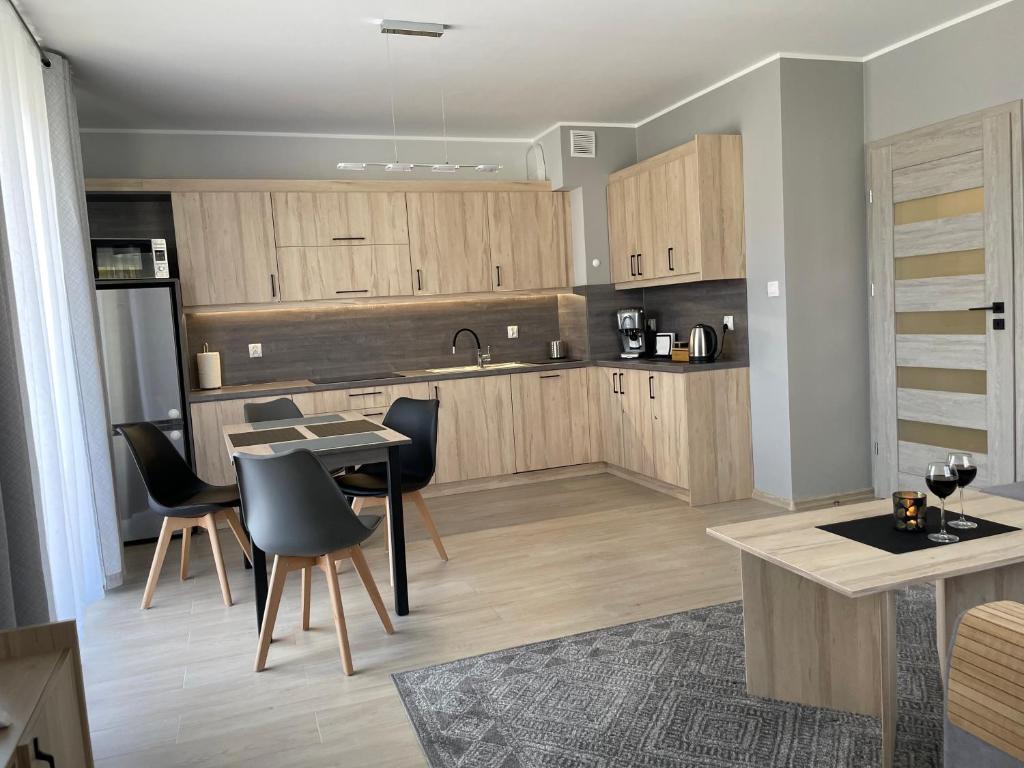 a kitchen with wooden cabinets and a table and chairs at Apartament AB Villa Mountain View Szklarska Poręba in Szklarska Poręba