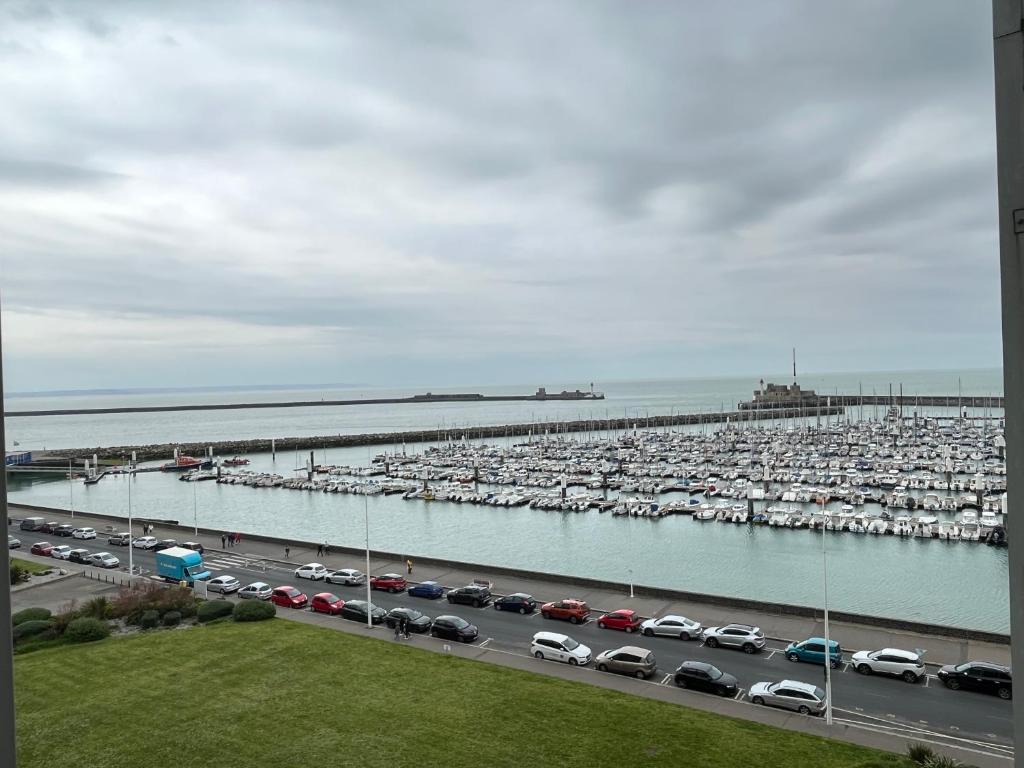 un aparcamiento con coches estacionados junto a un puerto deportivo en Vivez l'Horizon sur la mer - Vue mer - plage - Port de plaisance en Le Havre