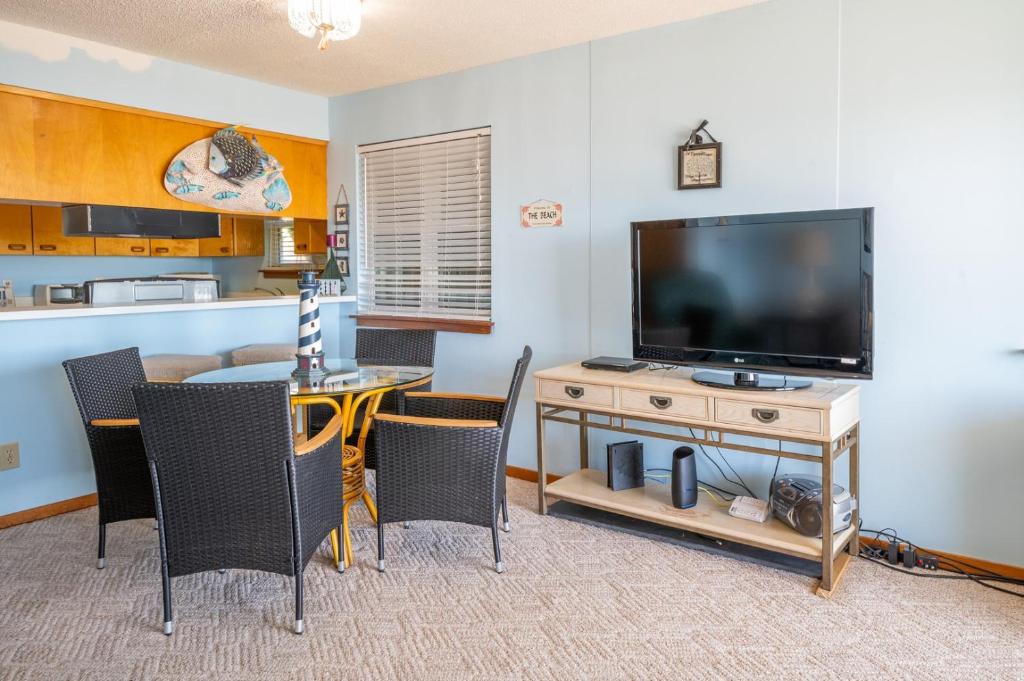 sala de estar con TV y mesa con sillas en 1305 S Lake Park Blvd, en Carolina Beach