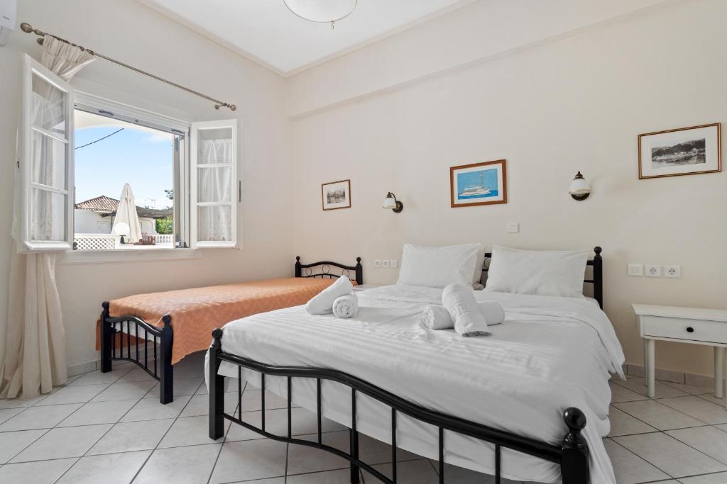 a bedroom with two beds and a window at Villa Kalomira in Spetses